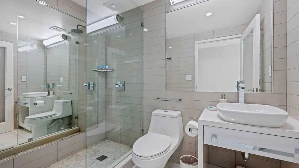 A clean and modern bathroom with a shower, toilet, and sink.